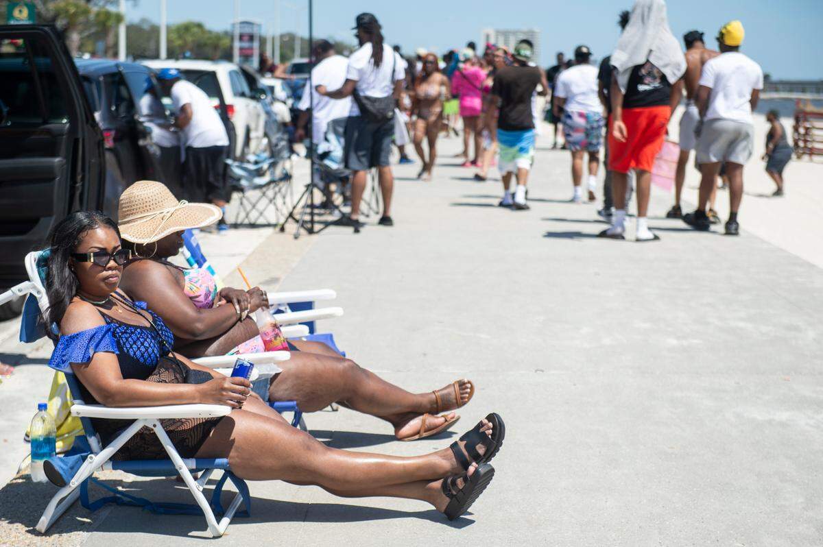 Spring breakers relax next to Biloxi Beach during Black Spring Break on Saturday, April 13, 2024.