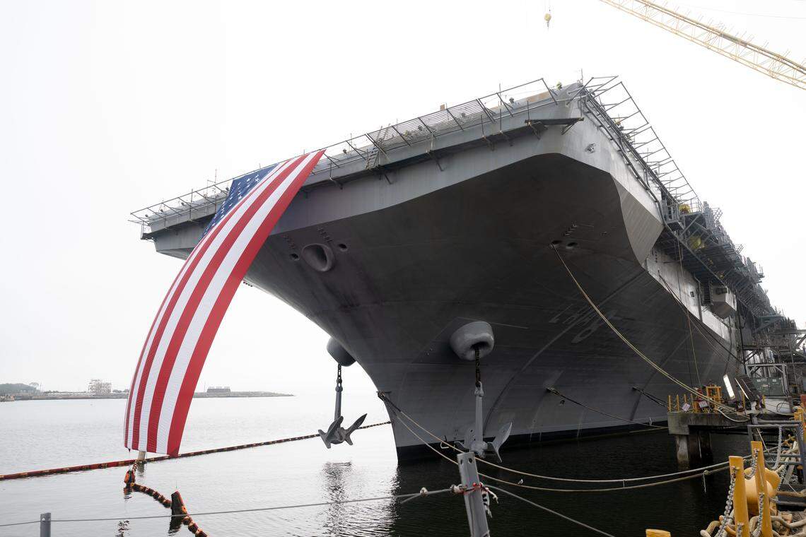 An American flag hangs off the side of LH8 Bougainville, a new amphibious assault ship, during a press conference at Ingalls Shipbuilding on Wednesday, Jan. 7, 2026.