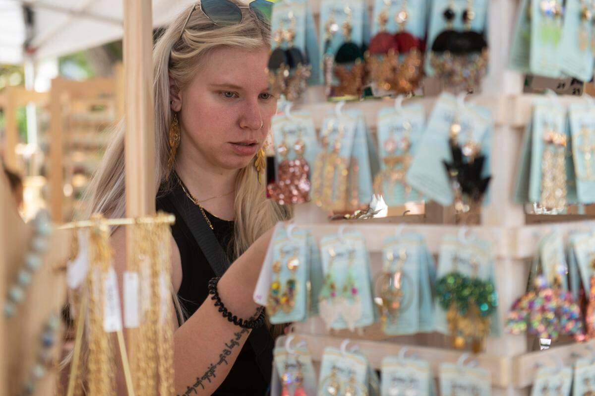 Brittany Villers, of St. Martin, admires jewelry for sale during the Peter Anderson Festival in Ocean Springs on Sunday, Nov. 6, 2022.