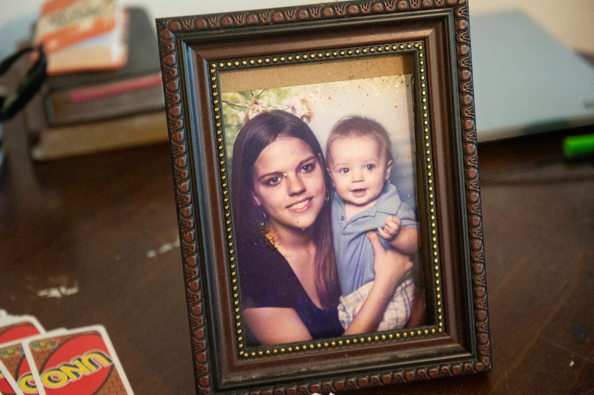 A photo of Bob Kiesau’s daughter, Kayla Kiesau, who died of a brain aneurysm in 2016, and his grandson Hayden sits on a table in his Ocean Springs home on Monday, Aug. 5, 2024. Kiesau, who is 83, is hoping to raise money to restore his home so his grandson, whom he adopted, will have a place to live after he is gone.