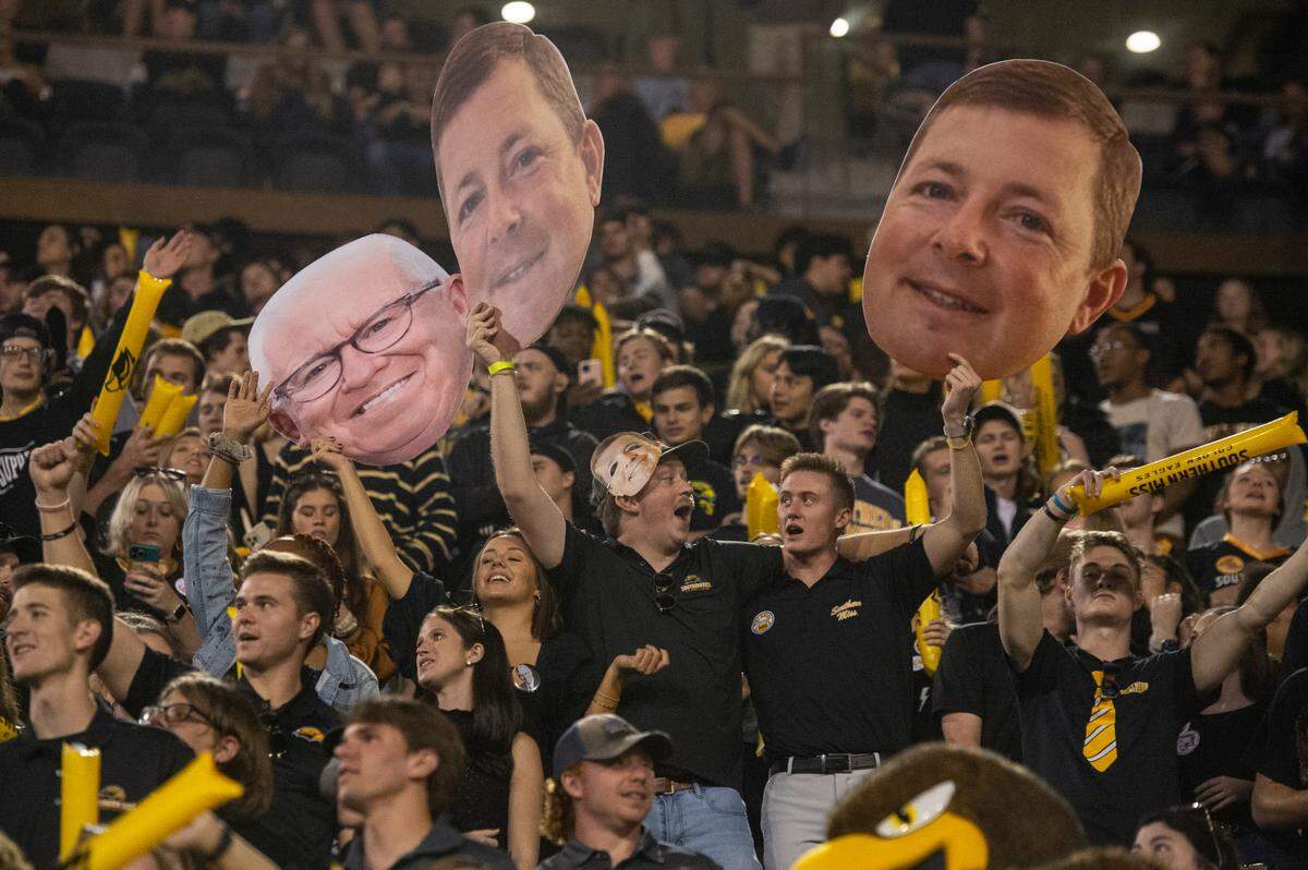 Southern Miss fans hold cutouts of Southern Miss Head Coach Will Hall during the first half of an NCAA college football game in Hattiesburg, Miss., Thursday, Oct. 27, 2022. (Hannah Ruhoff/The Sun Herald via AP)