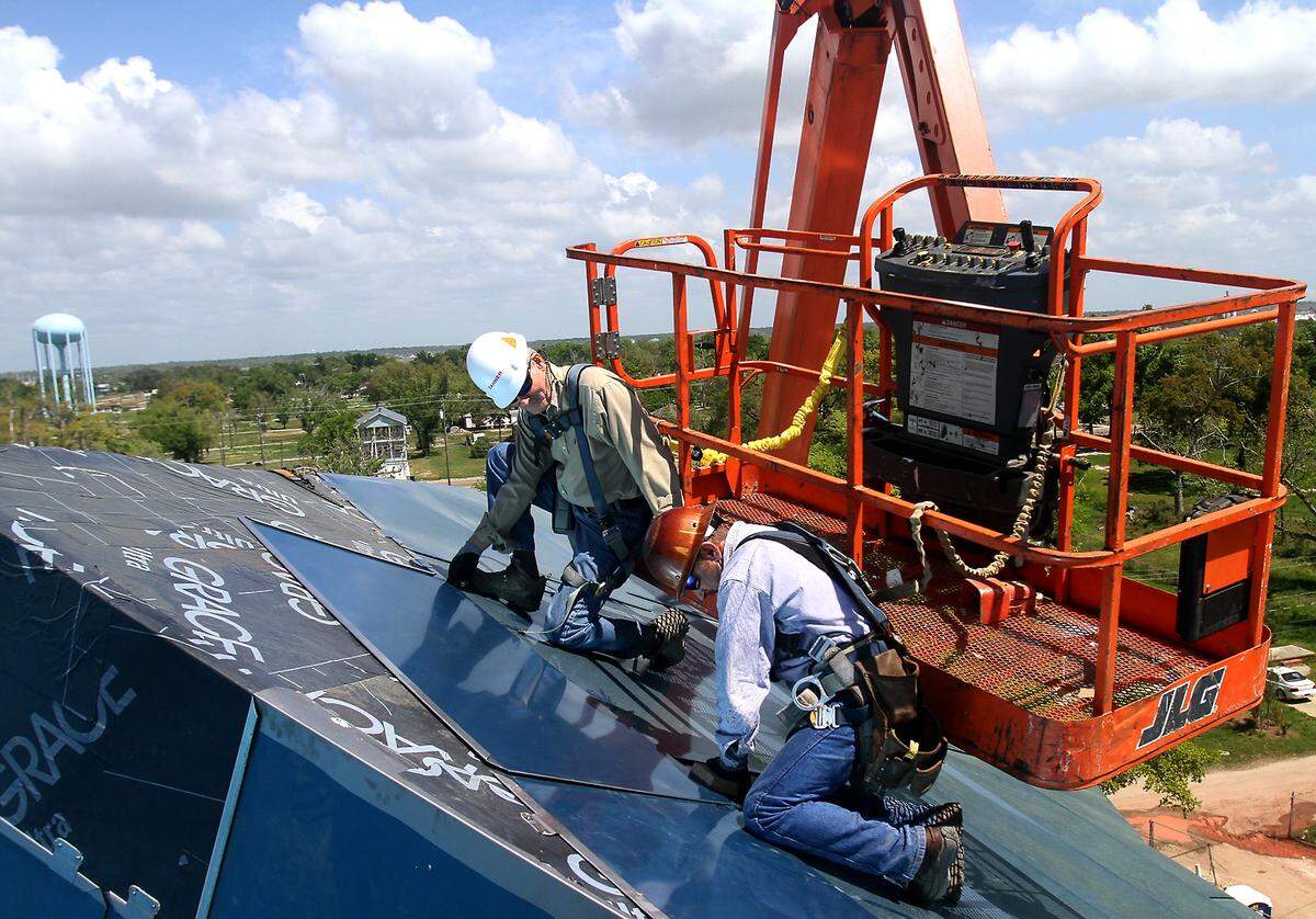 High above the ground, Roland Weeks, left, and Keith Teeny attach one of the last stainless steel sheets onto the roof of the Mississippi Sound Welcome Center at the Ohr-O'Keefe Museum of Art campus on Wednesday, April 14, 2010. Weeks and Teeny, field superintendent for A. Zahner Co., were given the honor because of their long work and dedication to the project.