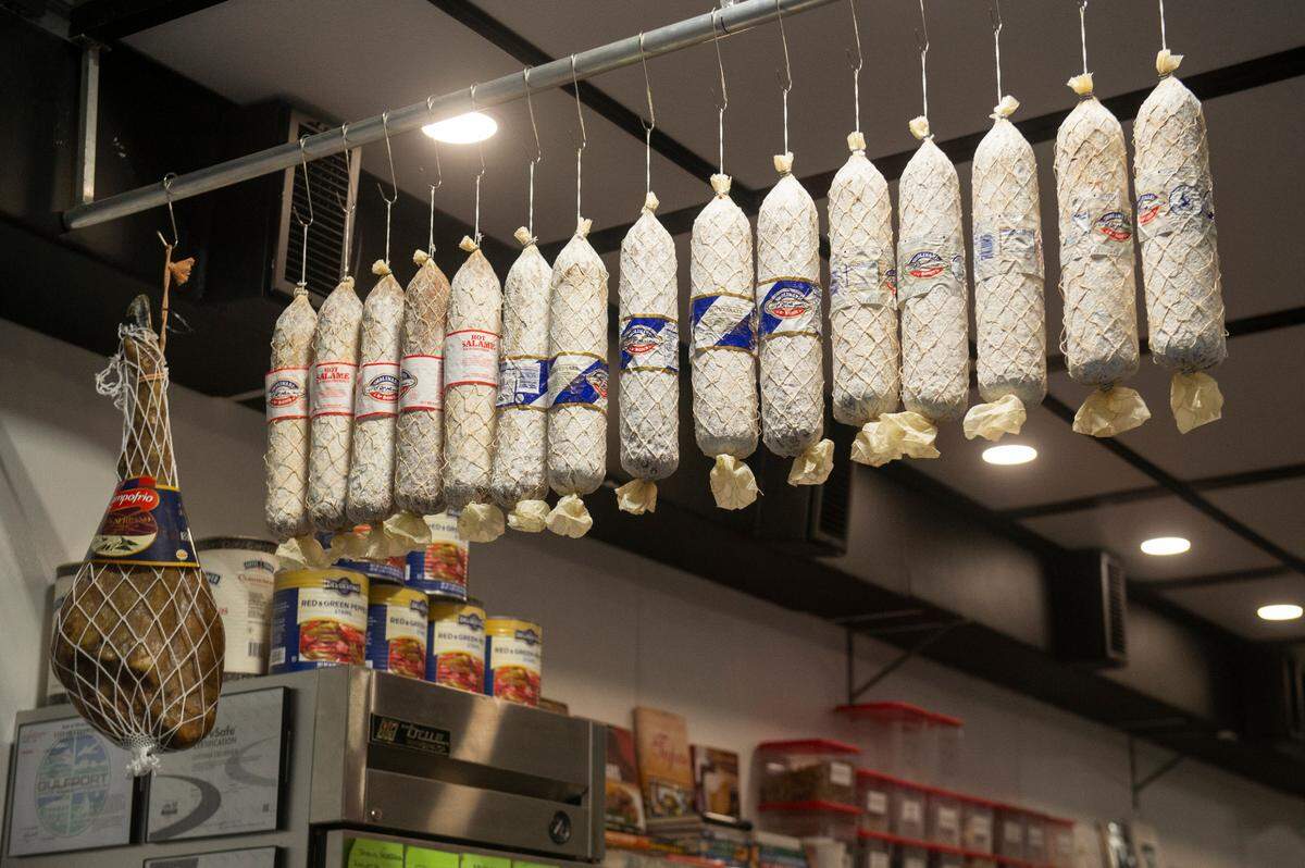Meats hang from the ceiling at Tavi’s Salumeria in Gulfport, where all the meats, cheeses and bread are imported.