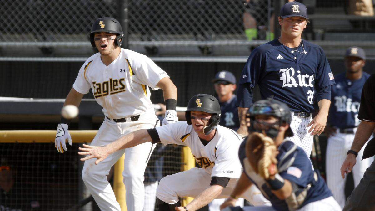 TIM ISBELL/SUN HERALD 
 Michael Gilbert of Southern Miss gives Chuckie Robinson directions to slide during game against Rice, Saturday, Apr. 23, 2016.