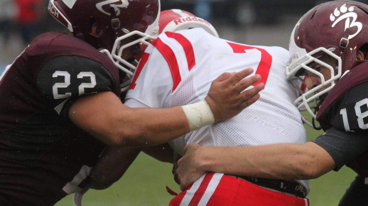 JOHN FITZHUGH/SUN HERALD 
 Biloxi Long Beach defenders Kevin Wayne, left, and Mitchell McCaleb hit Biloxi running back Martel Turner during the first quarter of their Shrimp Bowl game at Milner Stadium in Gulfport on Aug. 21. Wayne recently became his school's career tackles leader.