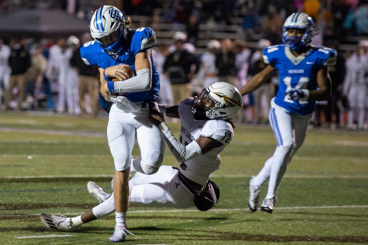 Ocean Springs’ quarterback Bray Hubbard gets tackled by Oak Grove’s Talan Watts during a 6A playoff game at Greyhound Stadium in Ocean Springs on Friday, Nov. 18, 2022.