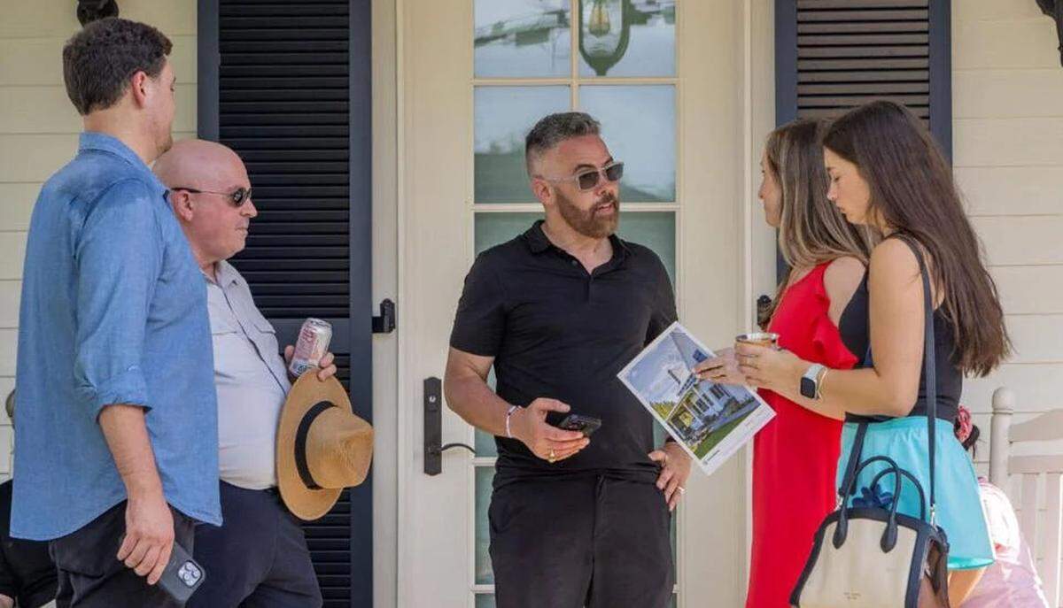 Josh Morgerman, center, chats with people from the Louisiana Department of Insurance at his “hurricane house” party in Bay St. Louis on June 7, 2025.
