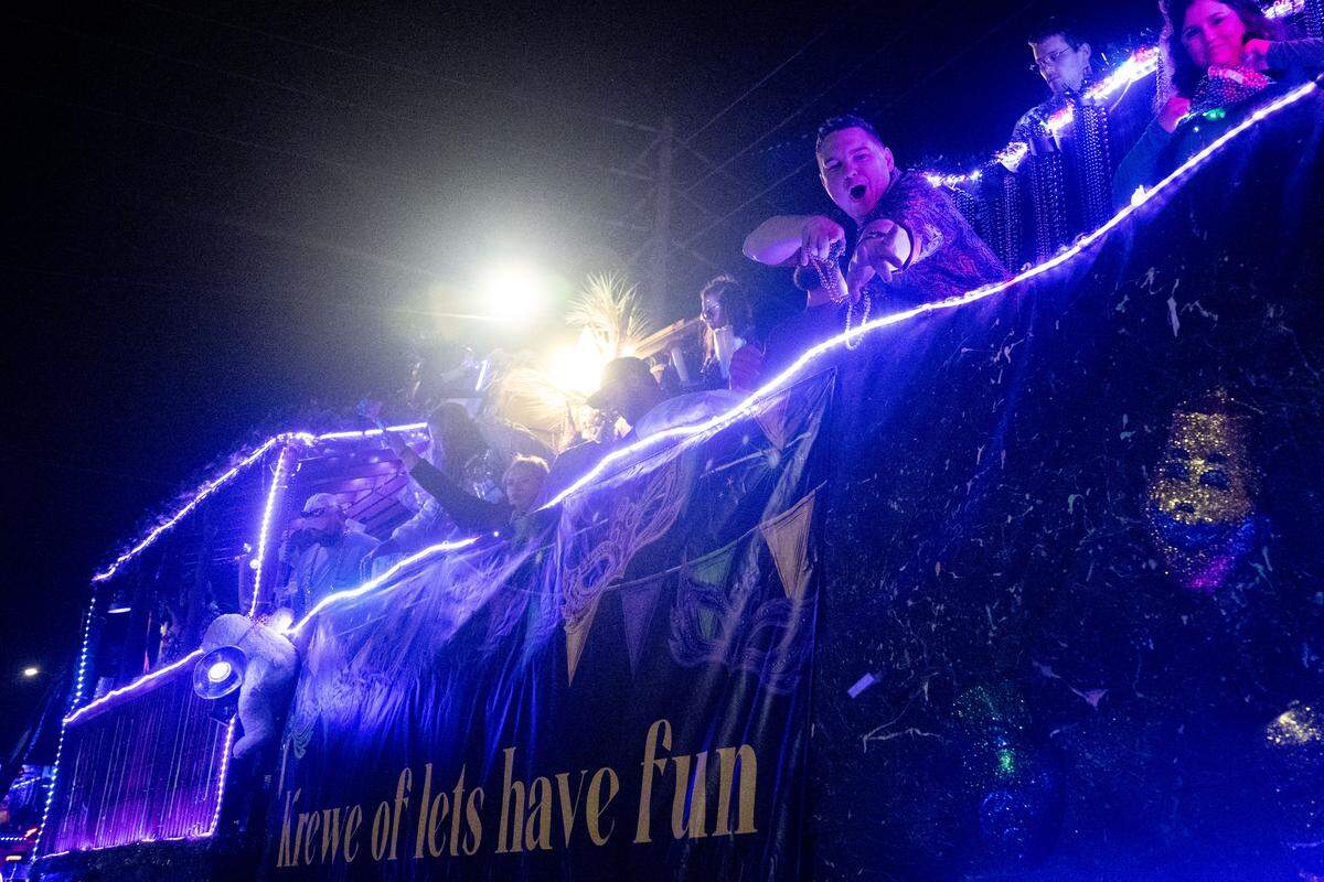 Parade participants cheer as they drive through Howard Avenue during the Krewe of Neptune parade in Biloxi on Saturday, Feb. 14, 2026.