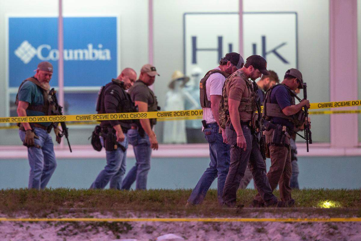Law enforcement officers canvas the ground looking for evidence outside Surf Style in Biloxi after a chaotic shooting during Black Spring Break that left one police officer injured on Sunday, April 16, 2023.
