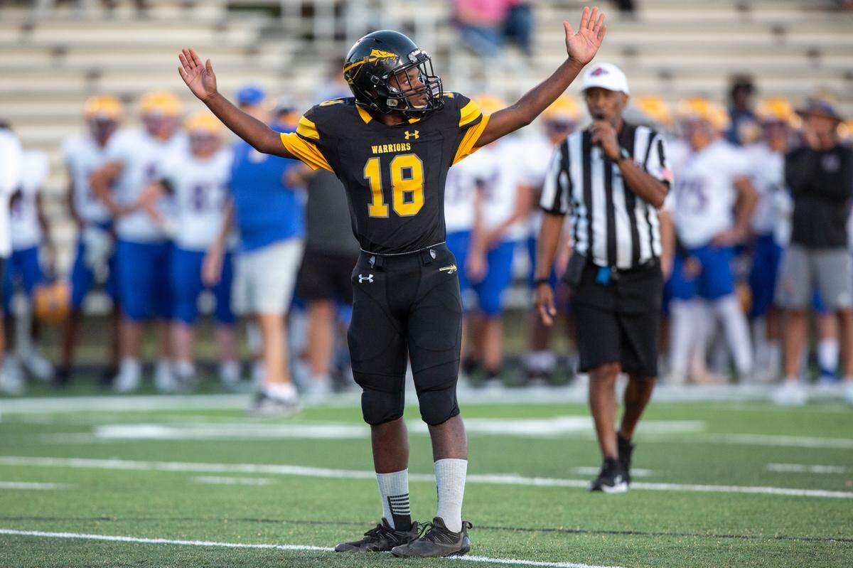 Tyler Hunter, the student manager for D’Iberville’s JV football team, hypes up the crowd before taking the snap in a game against St. Martin at Warrior Stadium in D’Iberville on Monday, Oct. 9, 2023. Both teams made accommodations so that Hunter, who has an intellectual disability, could get playing time.