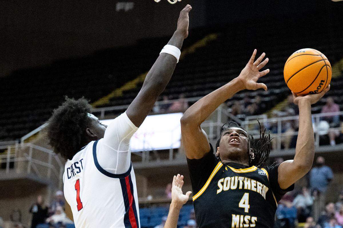 Southern Mississippi forward Tylik Weeks (4) takes a shot while defended by Mississippi forward Corey Chest (1).