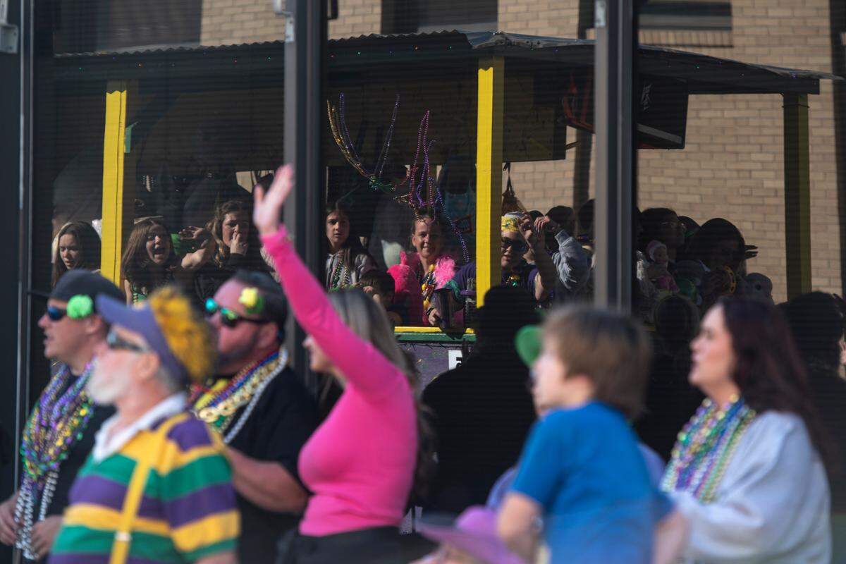 A float rider throws beads during the Gulf Coast Carnival Association’s Mardi Gras parade in Biloxi on Tuesday, Feb. 13, 2024.