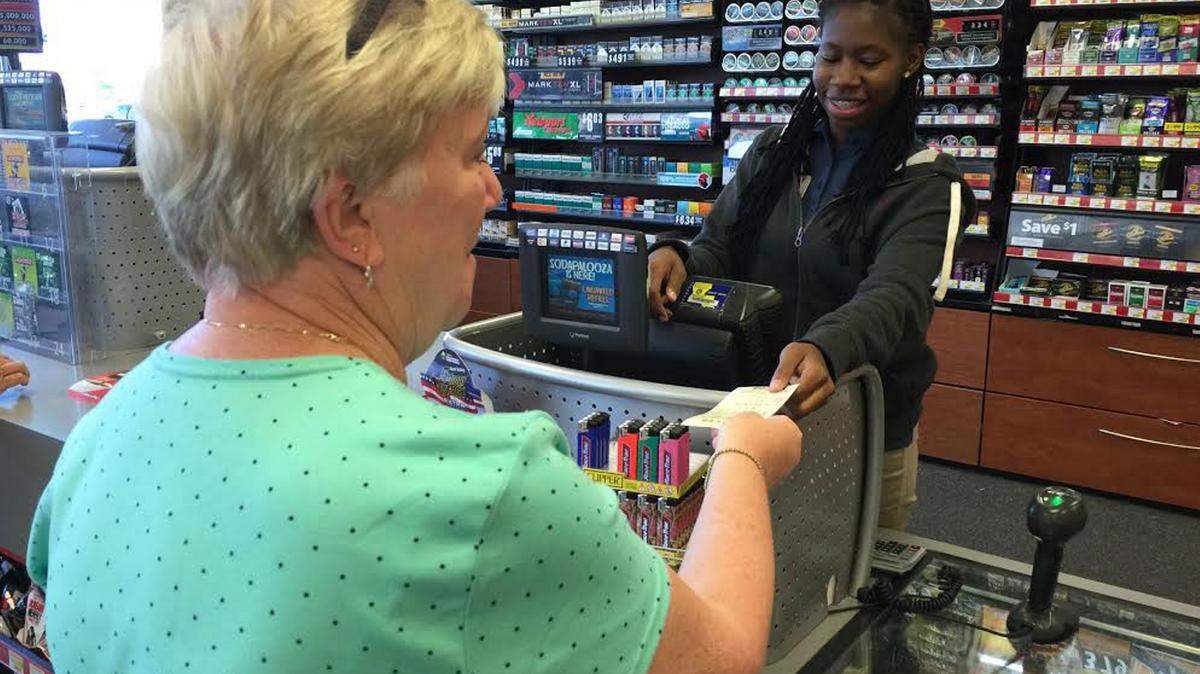 JEFF CLARK/SUN HERALD 
 Mikell Bankston sells a Powerball Lottery ticket to a customer Friday, May 6 at the RacTrac store in Slidell.