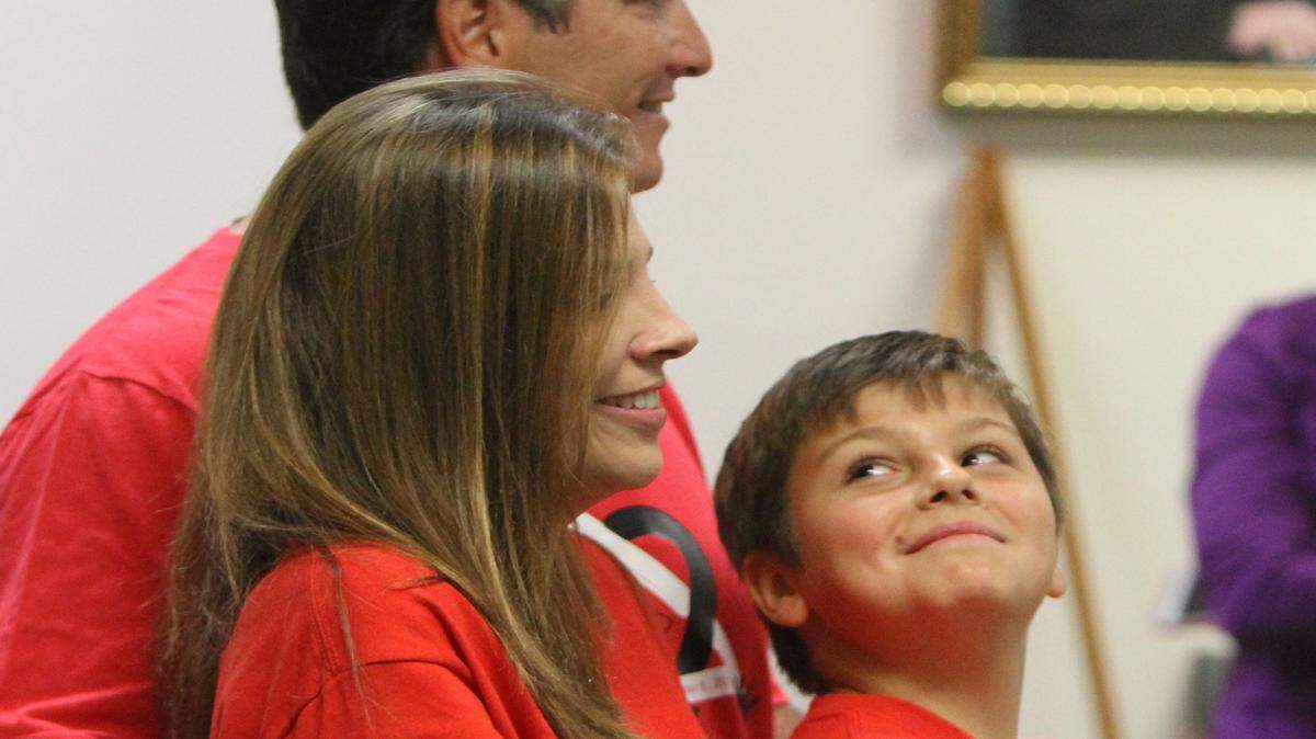 JOHN FITZHUGH/SUN HERALD 
 Lee Calvin Garibell of Biloxi looks up at his new parents, Elizabeth and Arthur during their adoption ceremony at Jackson County Circuit Court in Pascagoula on Friday Nov. 6, 2015.