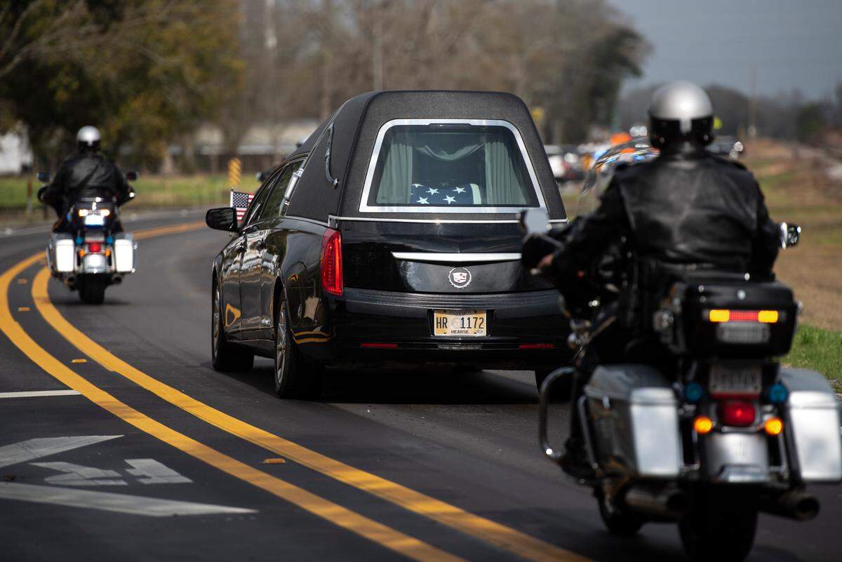 The casket of George County Sheriff’s Deputy Jeremy Malone is seen in a procession escorting Malone’s body from his funeral at Agricola Baptist Church in George County on Friday, Jan. 12, 2024.