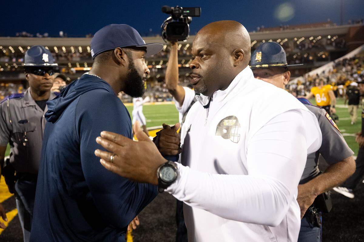 Southern Miss head coach Charles Huff shakes hands with Jackson State head coach T.C. Taylor after the Golden Eagles’ 38-20 victory Saturday.