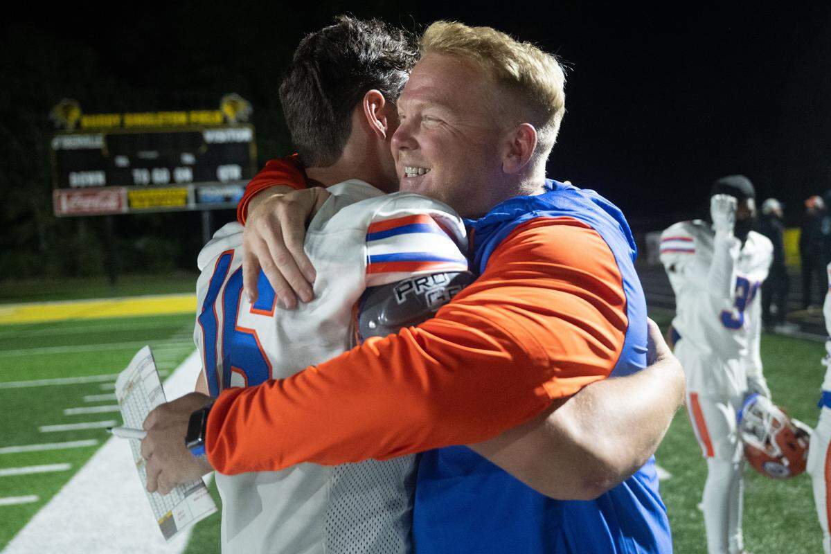 Gulfport head coach Blake Pennock celebrates Friday with quarterback Parker Nettles (16) after the Admirals captured the Region 4-7A title with a win over D’Iberville.