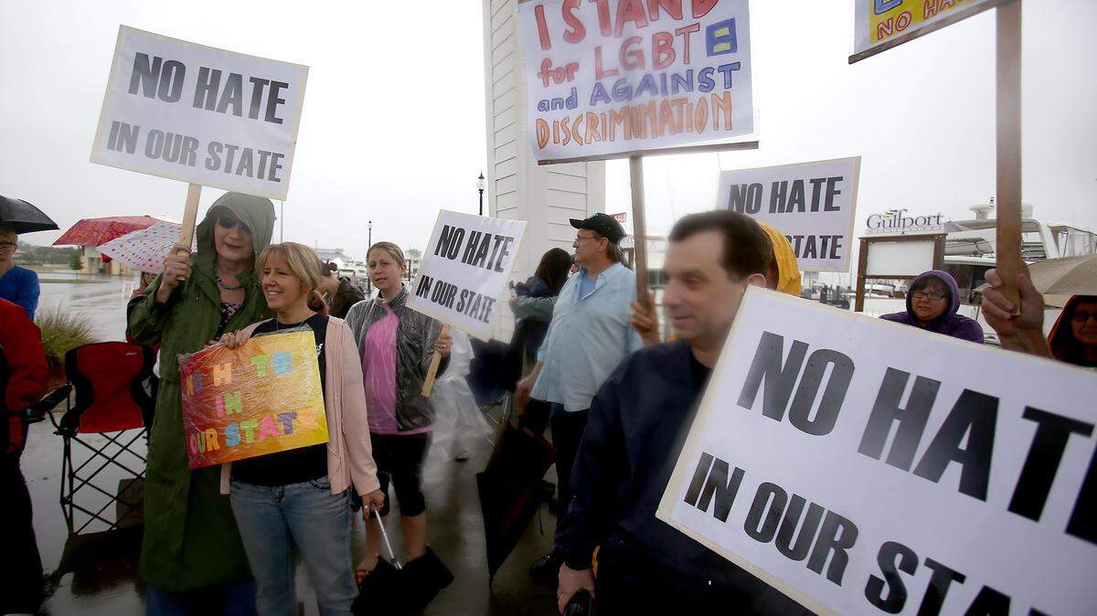 AMANDA McCOY/SUN HERALD 
 People gather at Jones Park to protest the passing of HB 1523, commonly known as the "religious freedom bill,Ó despite it being a rainy day on Wednesday, April 13, 2016. The rally comes on the same day that evangelist Franklin Graham is scheduled to hold the Mississippi Prayer Rally in Jackson.