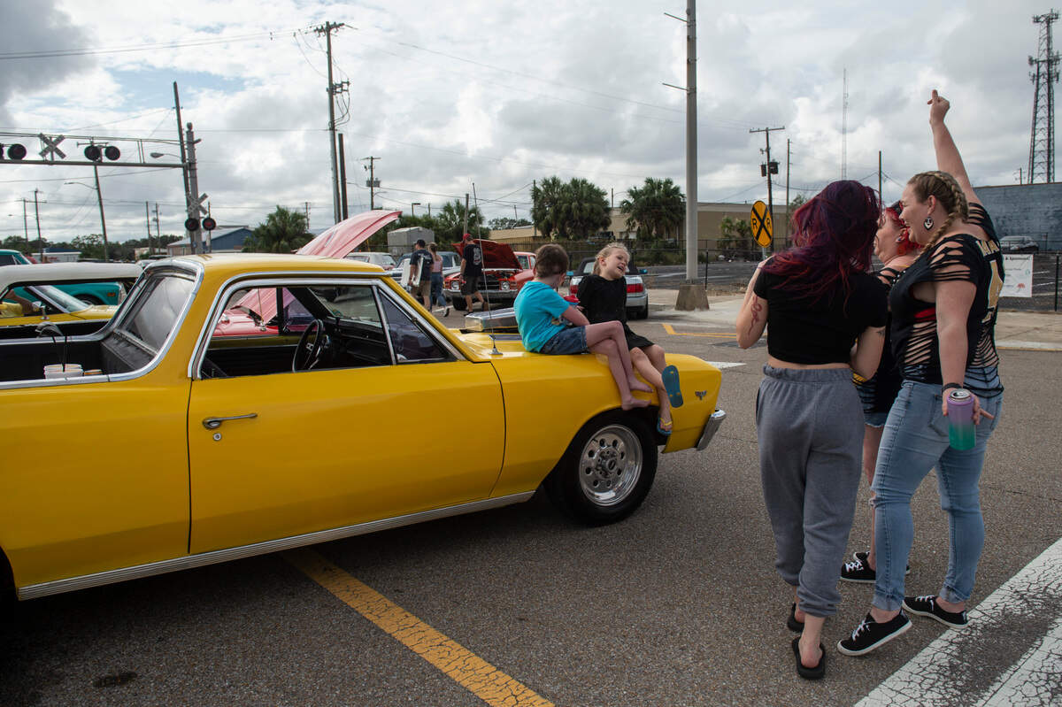 Danielle Capo, right, dances with her friends and children during View the Cruise on Sunday, Oct. 3, 2021. Danielle brought her husband’s yellow El Camino to the car show after purchasing it back from a friend they had sold it to 13 years ago on Friday.