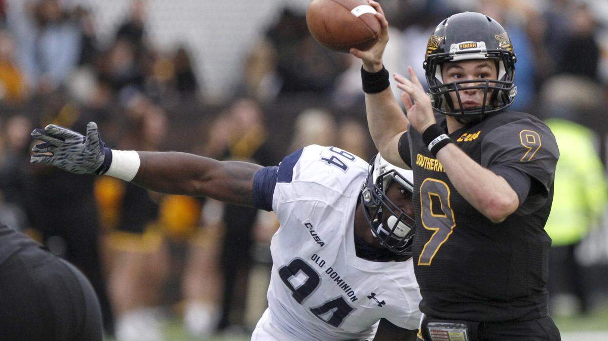 TIM ISBELL/SUN HERALD 
 Southern Miss quarterback Nick Mullens looks for an open receiver as Old Dominion's Scott Wiggins applies pressure, Saturday, Nov. 21, 2015.