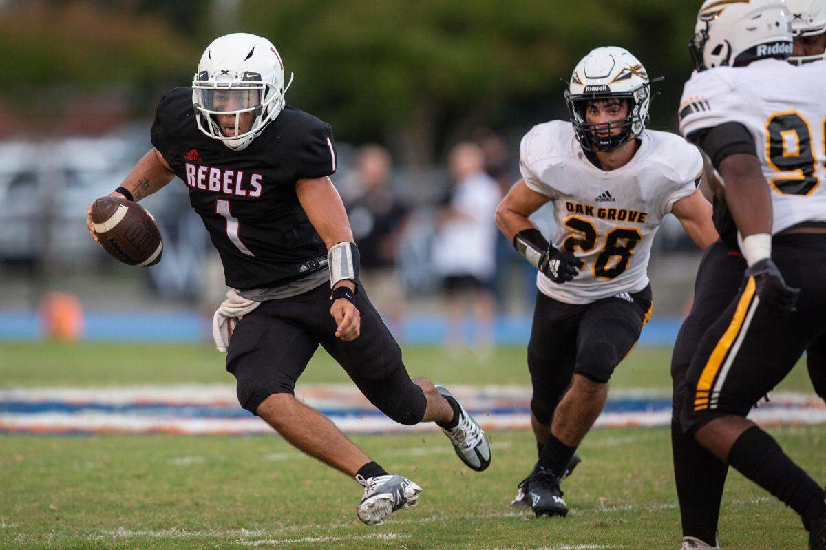 Harrison Central quarterback Christian Turner evades the Oak Grove defense during a game against Oak Grove at Milner Stadium in Gulfport on Friday, Aug. 26, 2022.