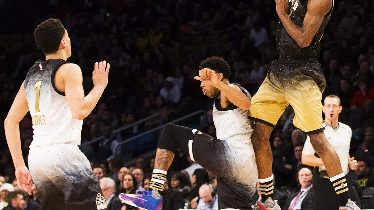 World forward Andrew Wiggins vies for the ball against United States' Devin Booker, left, and D'Angelo Russell, center, during the first half of the NBA Rising Stars Challenge basketball game in Toronto on Friday, Feb. 12, 2016. (Mark Blinch/The Canadian Press via AP)
