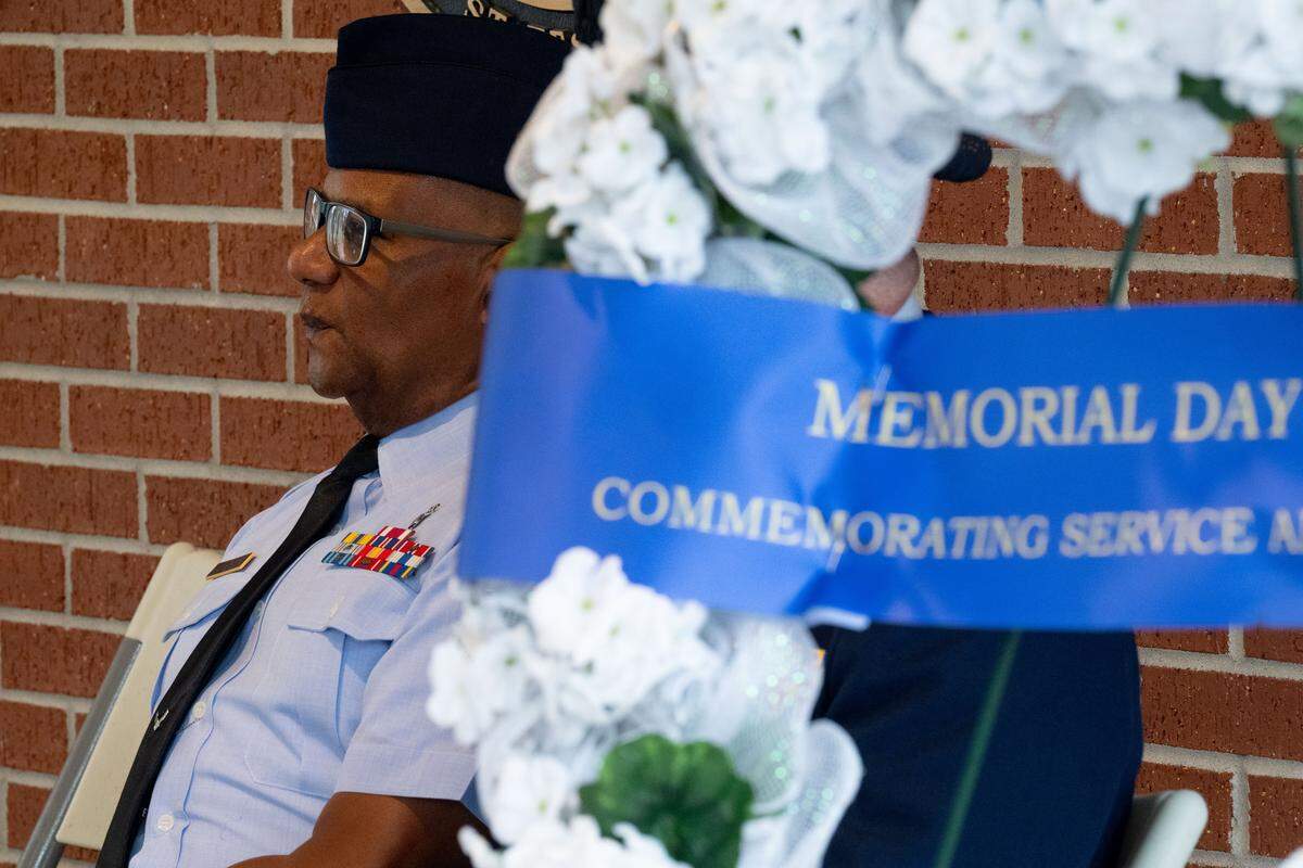 Master Sgt. Brian Lake sits behind a ceremonial wreath during a ceremony at Biloxi National Cemetery on Monday, May 25, 2026.