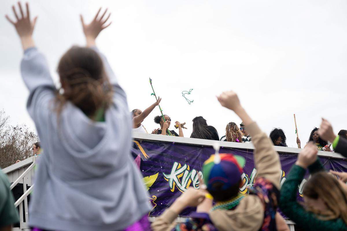 Members of the crowd cheer as floats pass down Lameuse Street.