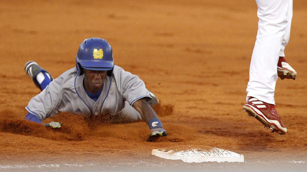St. Martin’s Leo Harris scrambles back to first after a fly ball was caught in shallow center field. 