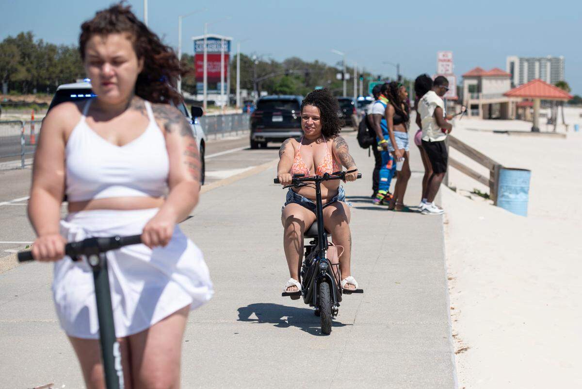 Spring breakers bike and scooter along Biloxi Beach during Black Spring Break on Saturday, April 12, 2025.