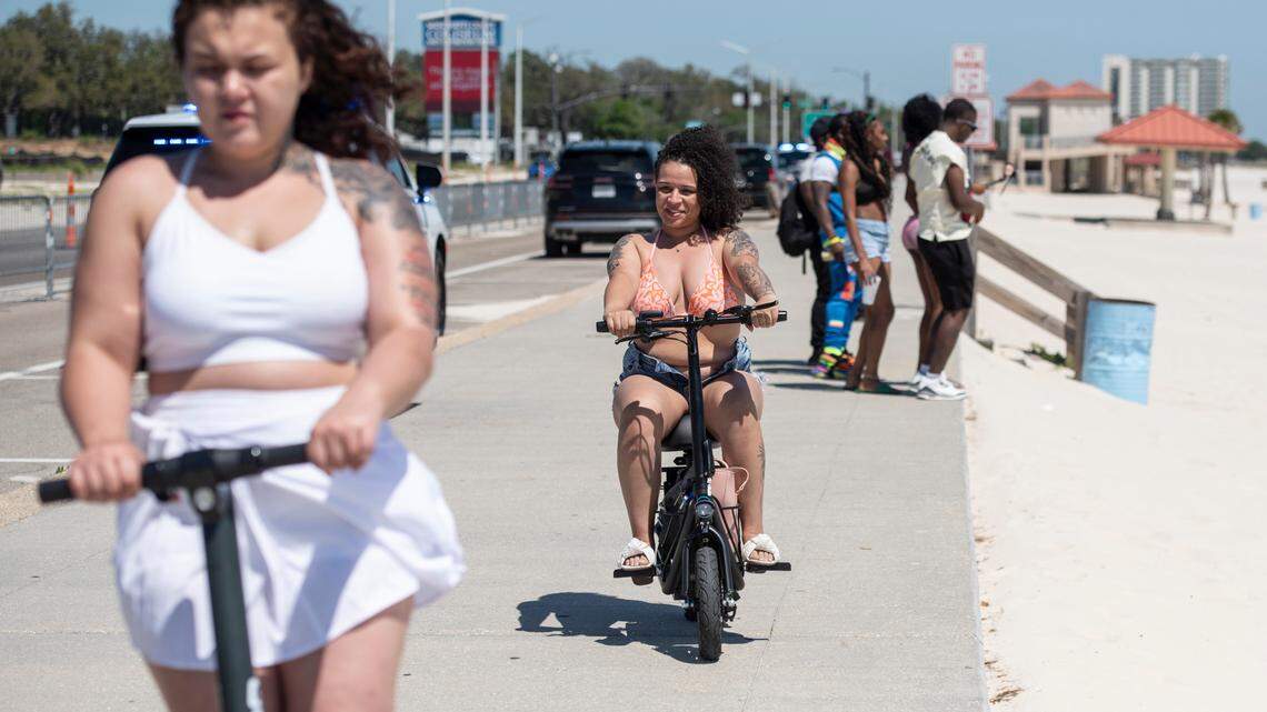 Spring breakers bike and scooter along Biloxi Beach during Black Spring Break on Saturday, April 12, 2025.