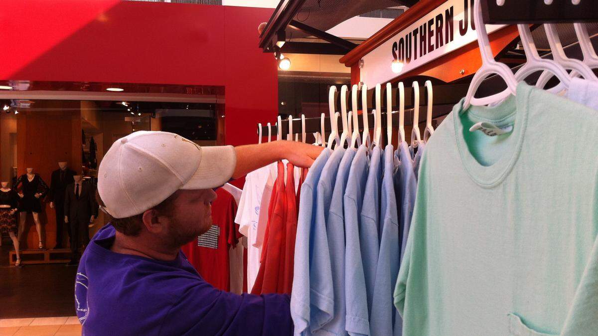 NATE THURMAN/SUN HERALD 
 Jason Daniel searches for a shirt at the Southern Junction kiosk at Edgewater Mall in BIloxi on Friday, Dec. 11., 2015.