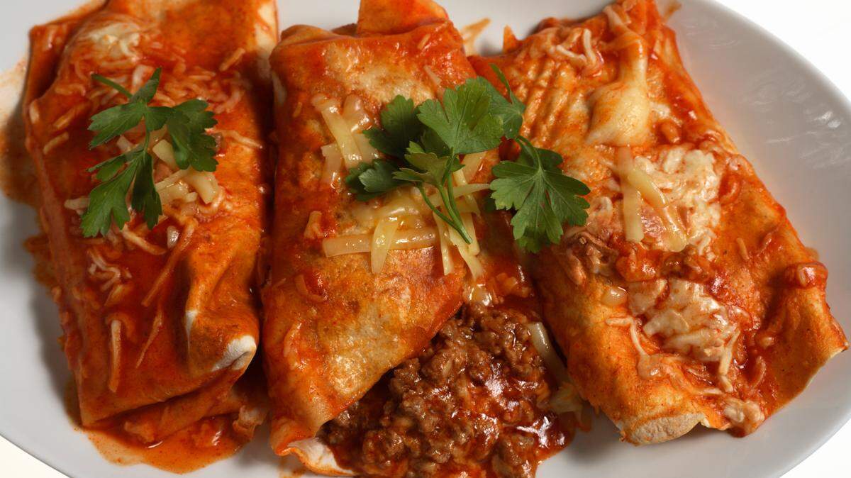 These traditional enchiladas have spicy ground beef wrapped in a corn tortilla and baked with a coating of tomato salsa and cheese. Mix it up with shrimp enchiladas and add an awesome ranchero sauce for a flavor boost.