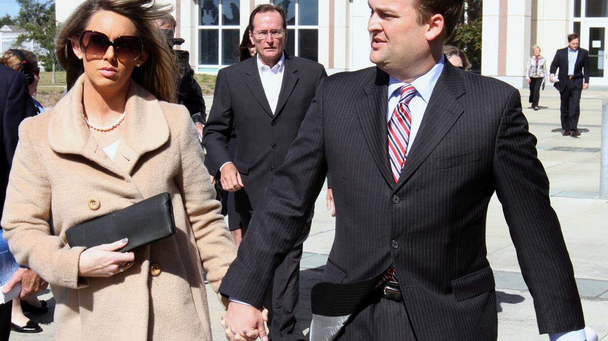 JOHN FITZHUGH/SUN HERALD 
 Scott Walker, right, his wife, Trinity and father, Bill, center, leave the Dan M. Russell Jr. federal courthouse in Gulfport after Scott and Bill's initial appearance Nov. 8, 2013, on public corruption charges.