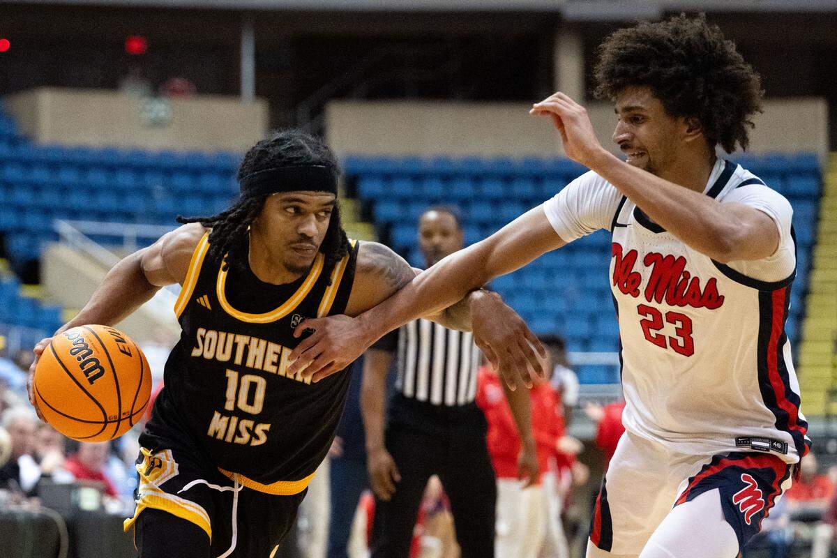 Southern Mississippi guard Isaac Taveras (10) dribbles the ball through contact against Mississippi guard Patton Pinkins (23).