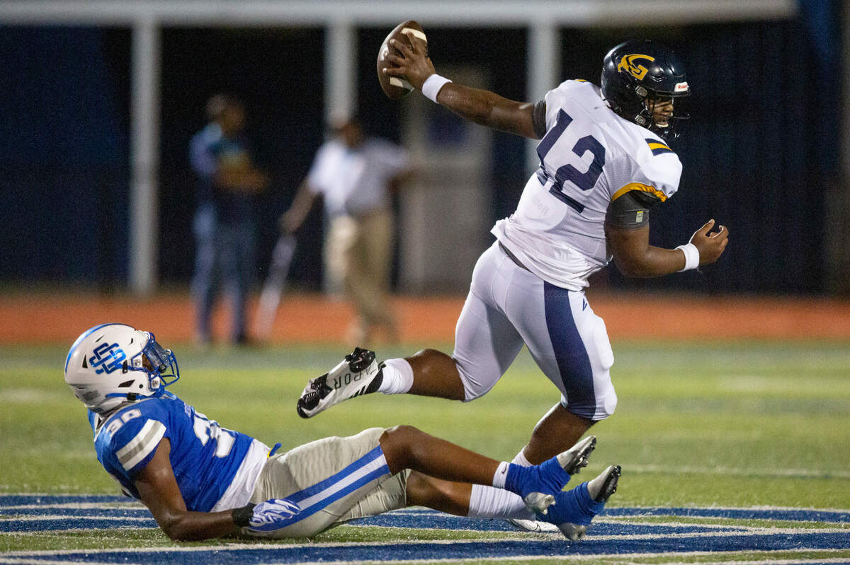 Gautier quarterback Kaden Irving avoids a tackle by Ocean Springs’ Ausmer Bryant during a Jamboree game at Greyhound Stadium in Ocean Springs on Friday, Aug. 19, 2022.