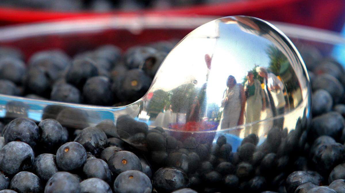 AMANDA McCOY/SUN HERALD 
 The reflection of those waiting for some free ice cream with blueberries is reflected in a serving ladle during the "Red, White, and Blueberry" festival in downtown Ocean Springs last year. Volunteers are sought to help with this year's festival on Saturday.