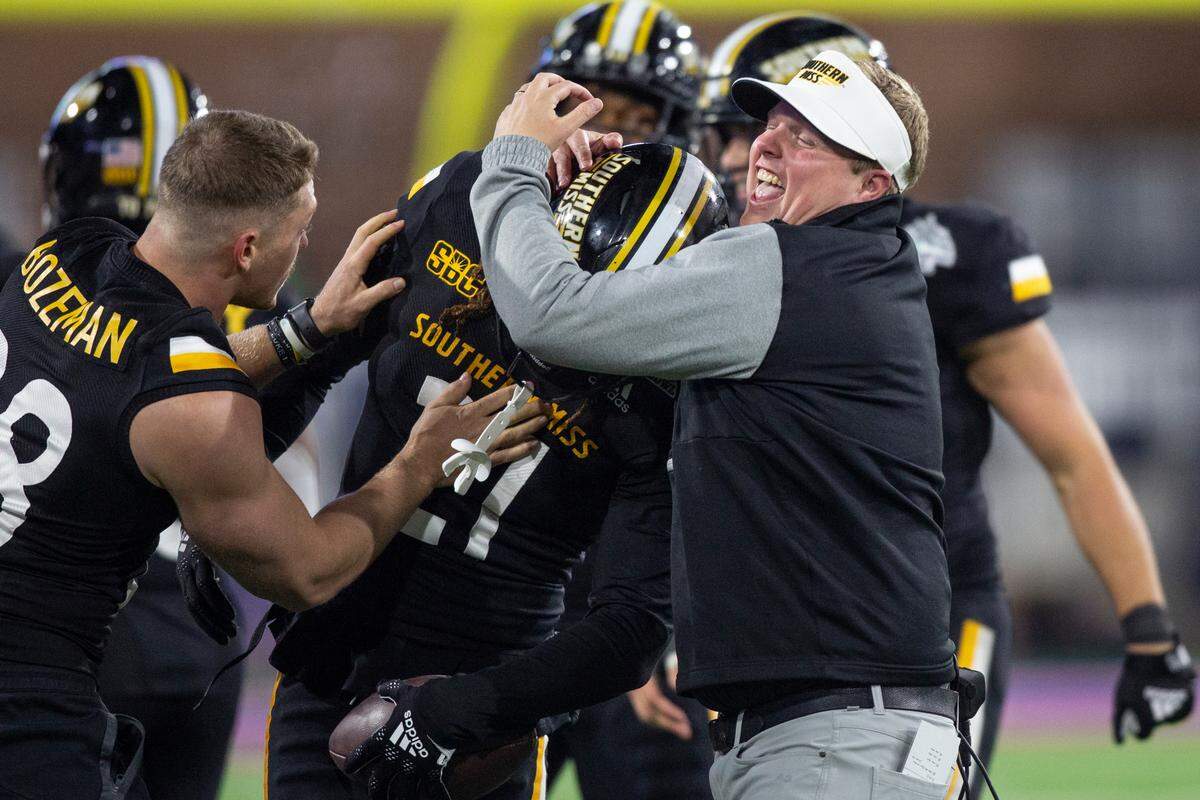 Southern Miss players celebrate with Defensive Coordinator Austin Armstrong after winning the Lending Tree Bowl at Hancock Whitney Stadium in Mobile, Alabama on Saturday, Dec. 17, 2022.
