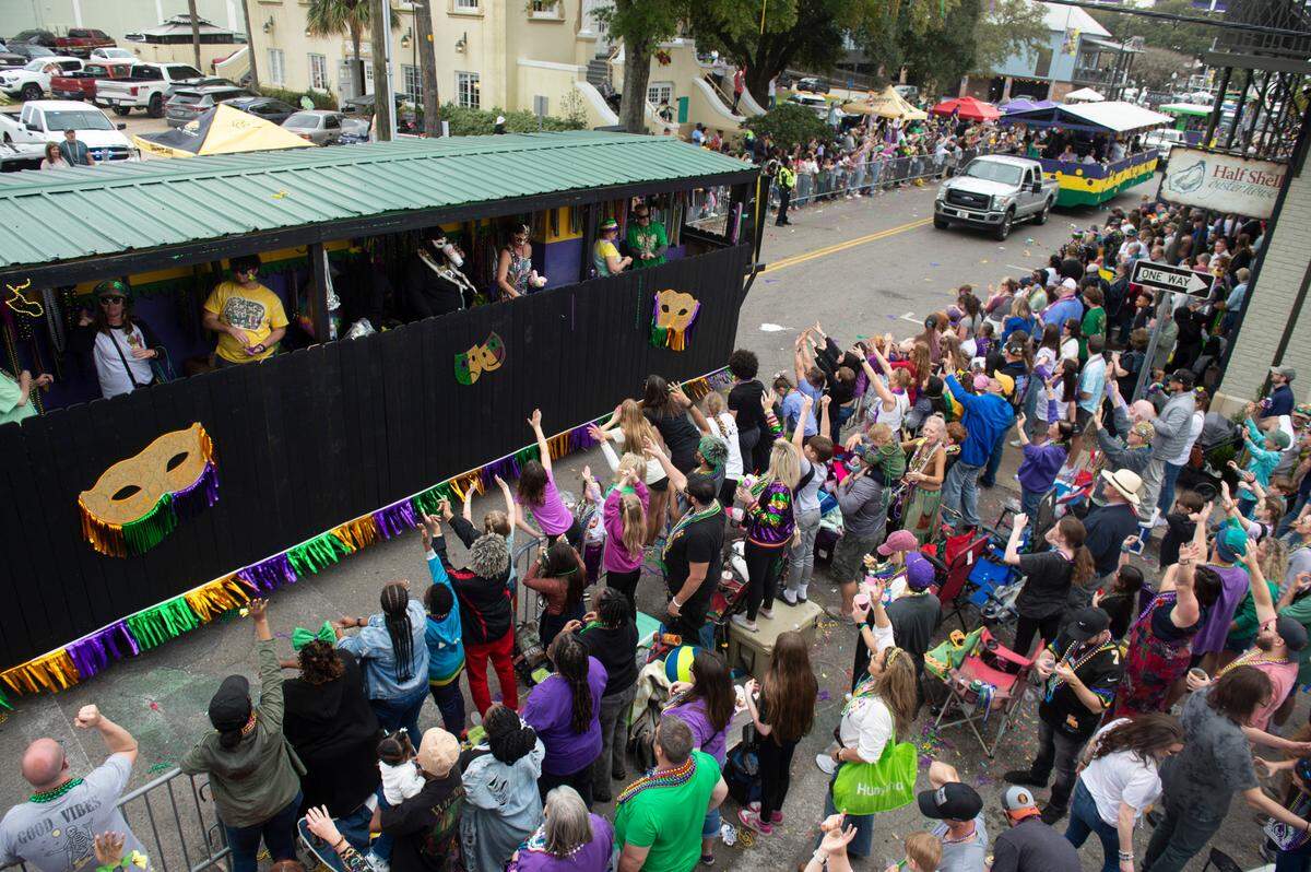 Parade watchers on Lameuse Street cheer for beads and other throws during the Gulf Coast Carnival Association Mardi Gras parade in Biloxi on Tuesday, March 4, 2025.