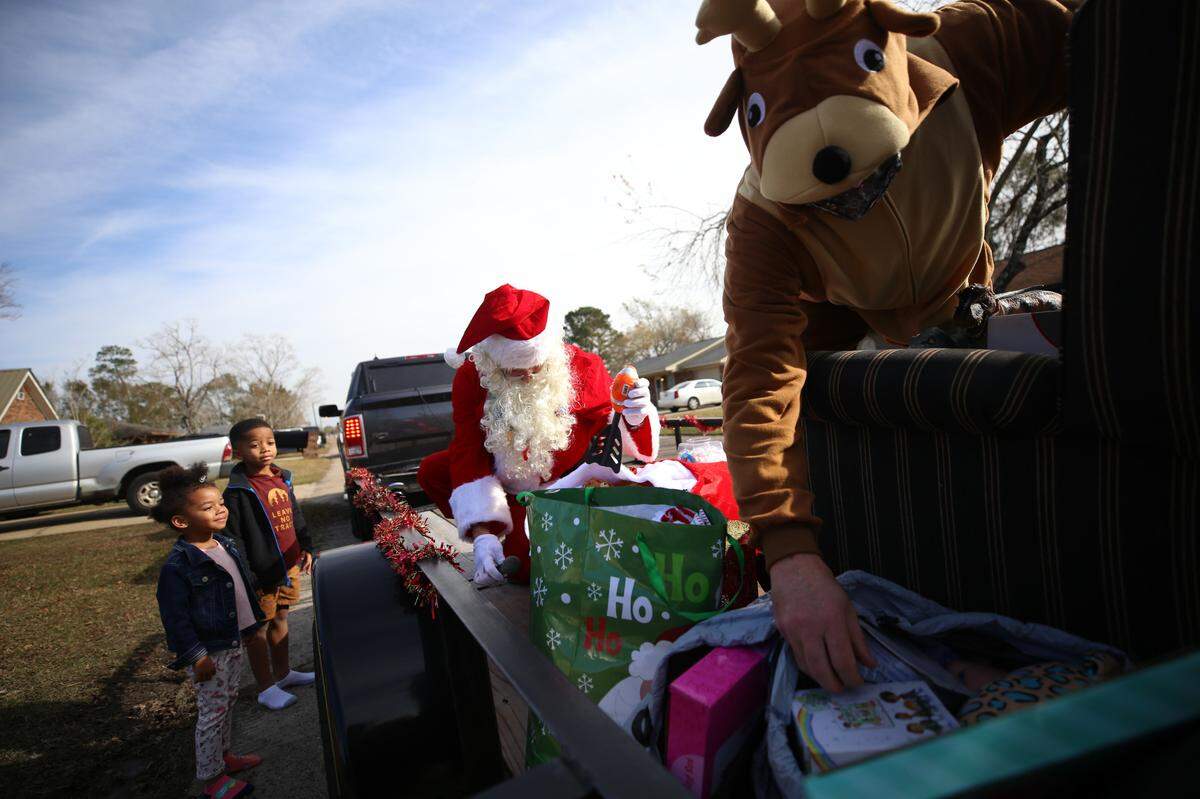 Hane and Brad Laneaux wait for a gift from Santa outside of their Biloxi home Saturday, Dec. 19, 2020.