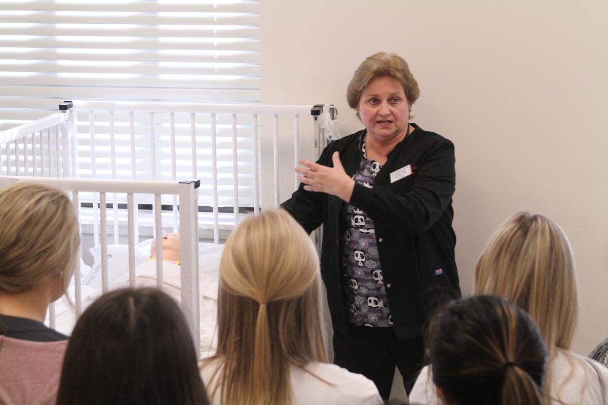 Deborah H. Chatham, coordinator of the master’s program as William Carey University’s Tradition Campus, talks to high school students about caring for patients, in this case a baby. Tradition is bringing together a network of education and training facilities focused on the health-care industry.