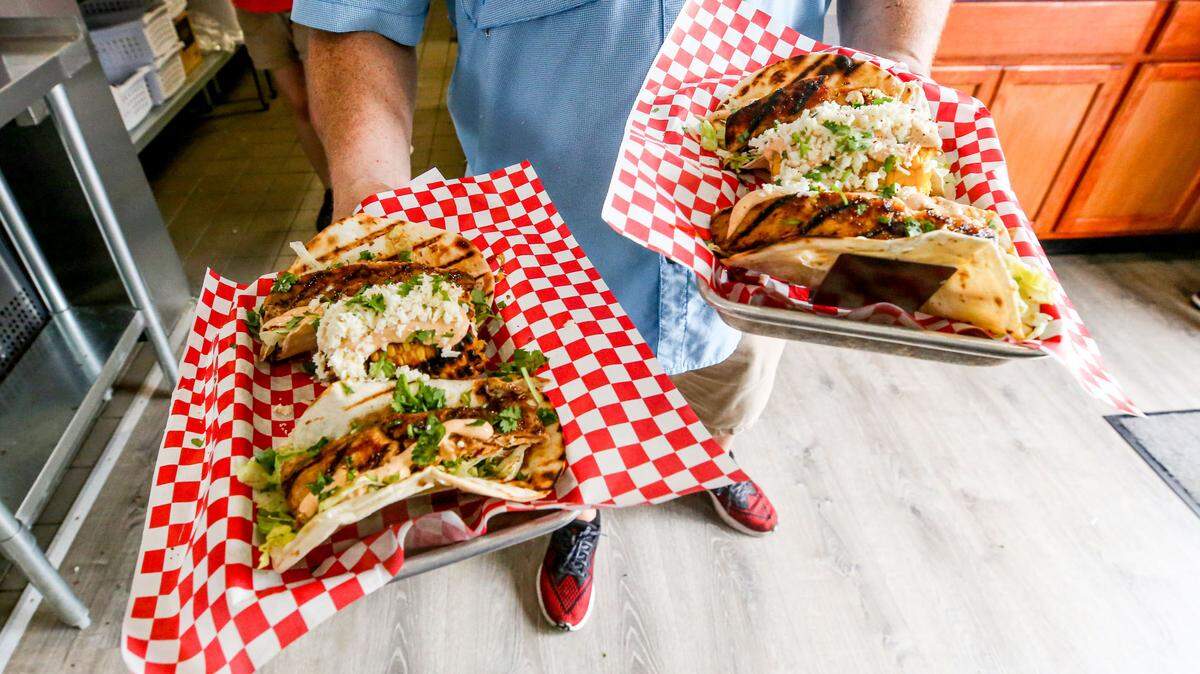 A Marina Cantina server shows some of the tacos the waterside restaurant offers. A taco, a burger and a drink special are featured each day.