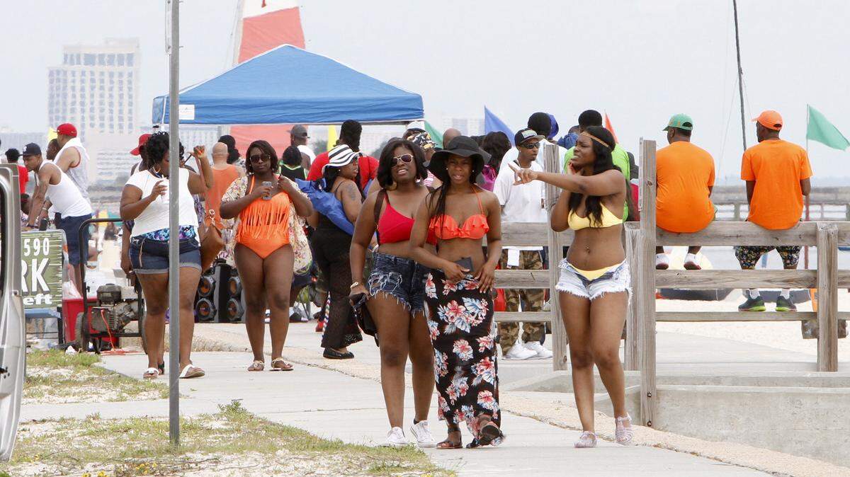 Spring breakers navigate their way past grills, tents and coolers during Biloxi Black Beach Weekend, Saturday, April 11, 2015.