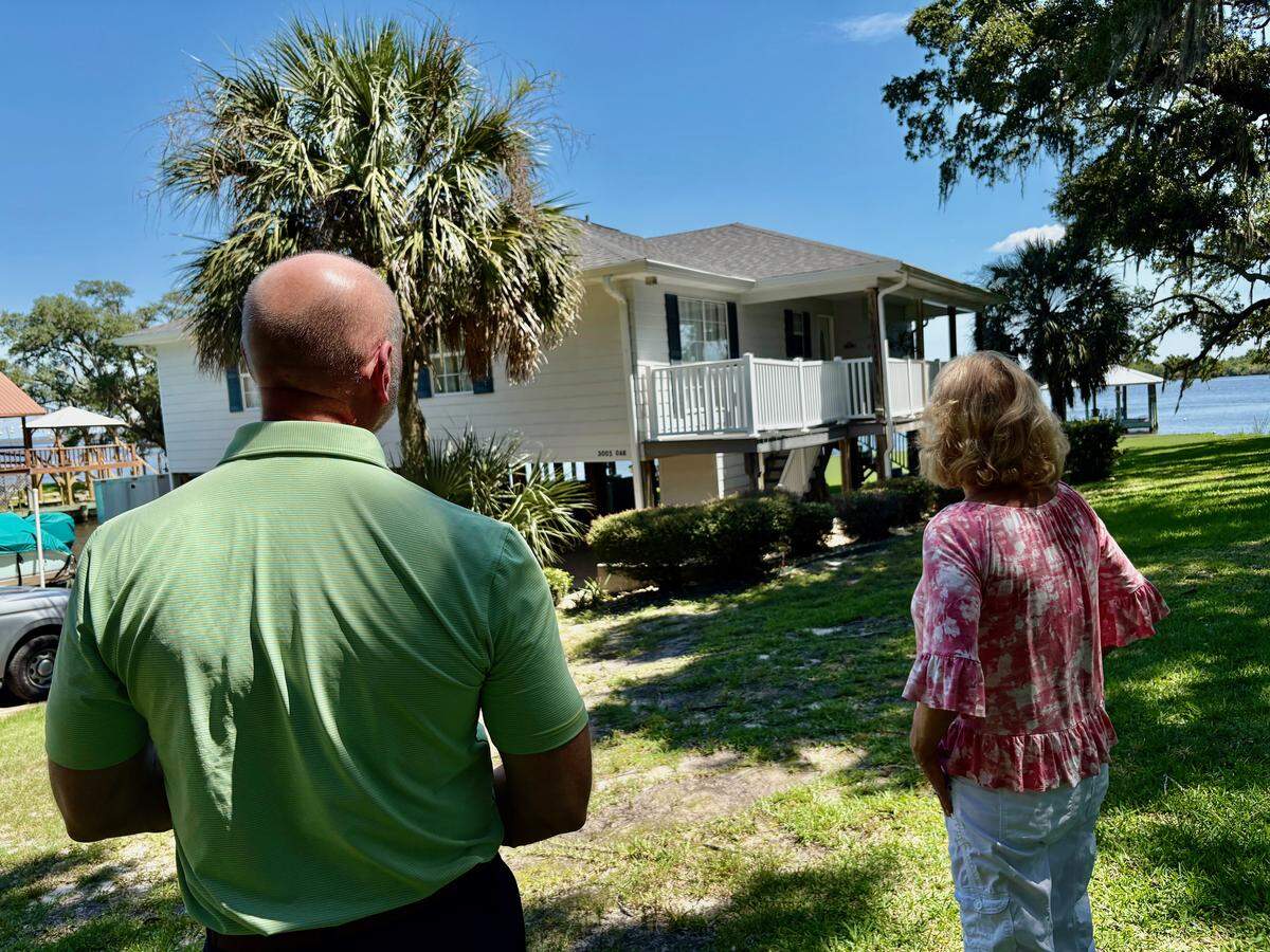 Andy Case, left, of the Mississippi Insurance Department and Gautier homeowner Beth Sanders look at her new roof. Sanders received a $10,000 grant to strengthen the roof against hurricane damage. The program is currently unfunded.
