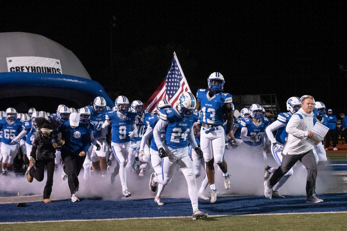 Ocean Springs’ Greyhounds run onto the field before a 6A playoff game against Oak Grove at Greyhound Stadium in Ocean Springs on Friday, Nov. 18, 2022.