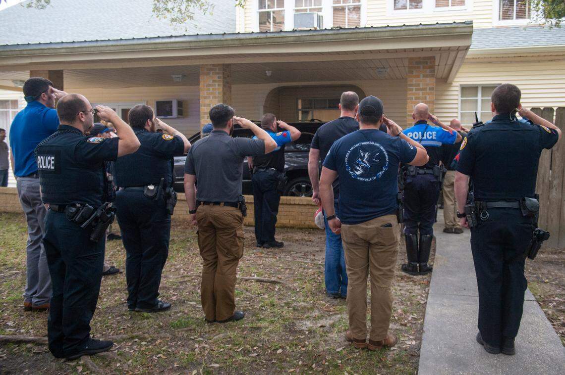 Law enforcement officers salute the body of Sgt. Steven Robin as it is taken into Edmond Fahey funeral home in Bay St. Louis on Wednesday, Dec. 14, 2022. Robin was killed along with another officer while on duty.