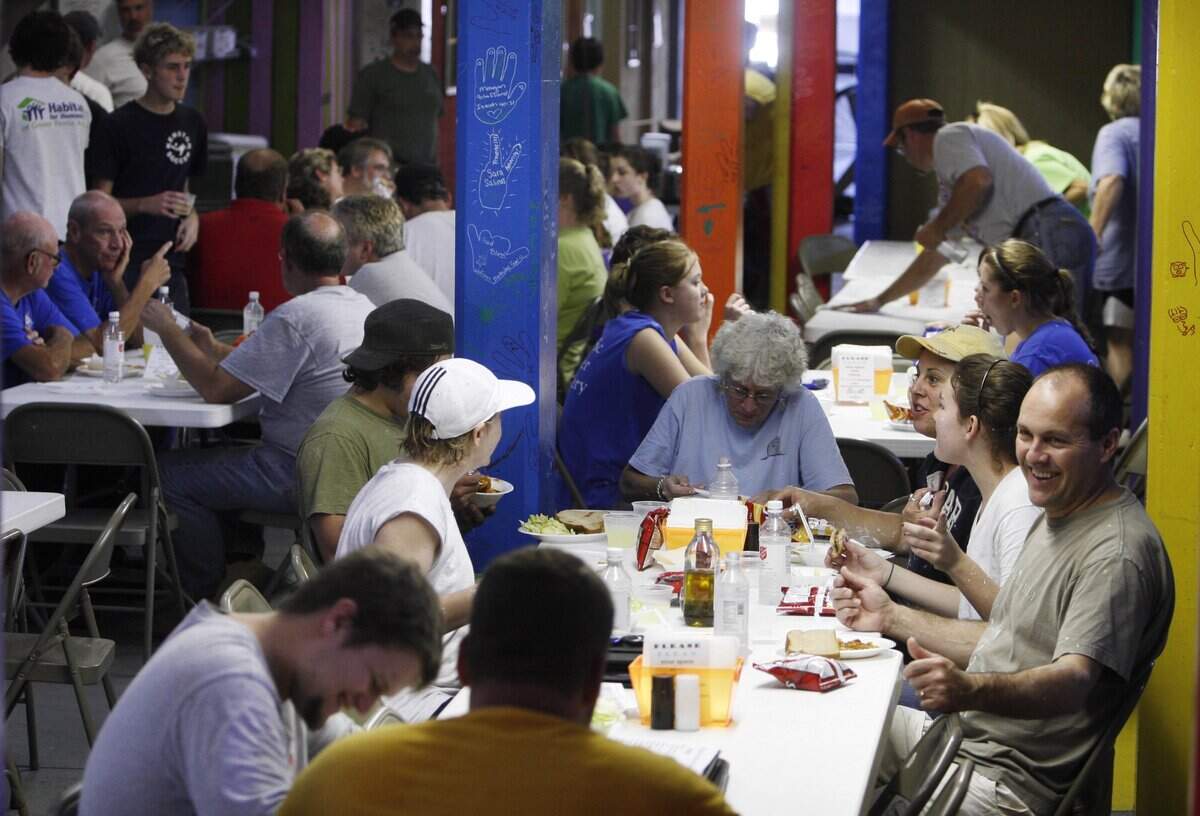 Tim Mueller of Biloxi, right, director of operations for Compassion First from the Beaverton Foursquare Church in Oregon, eats lunch at the Volunteer Village at Yankie Stadium  in Biloxi, where the Salvation Army housed and fed volunteers after Hurricane Katrina.
