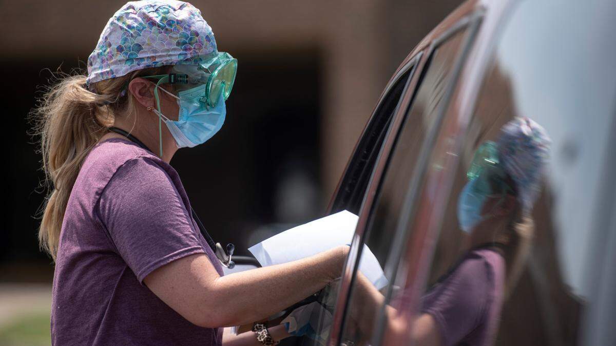 Nurse practitioner Angie Yawn gives a patient their COVID-19 test results in the parking lot of Memorial Hospital’s COVID-19 testing site in Gulfport on Monday, Aug. 23, 2021. According to Yawn, the site has seen an average of 450 people coming for tests each day.