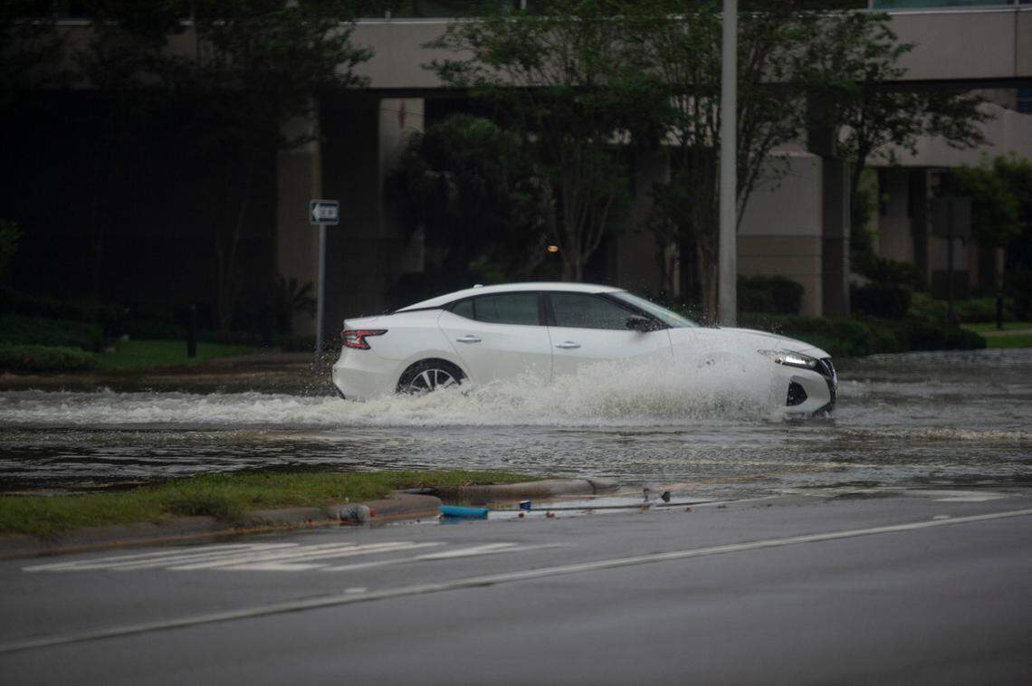 Cars drive through standing water on Highway 90 in Biloxi on Sunday..