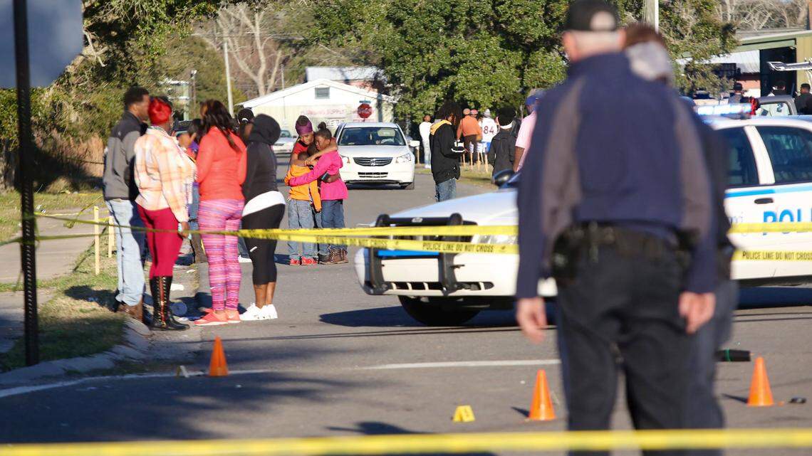 AMANDA MCCOY/SUN HERALDA woman embraces two children near the intersection of Davis Avenue and Ladnier Street in Pass Christian after a shooting on Feb. 7.